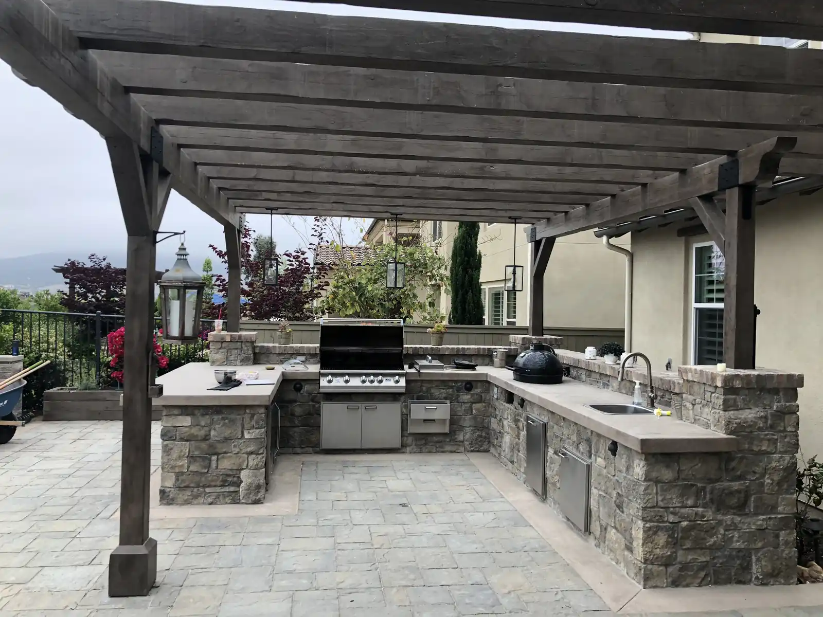 Custom outdoor kitchen under a wood pergola by Panjia Outdoors